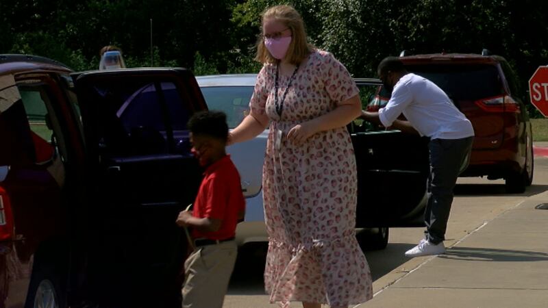 Teachers walk the students to their cars.