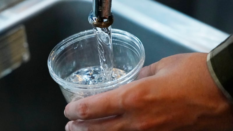 FILE - A cup of water is drawn from a faucet at Johnny T's Bistro and Blues, a midtown...