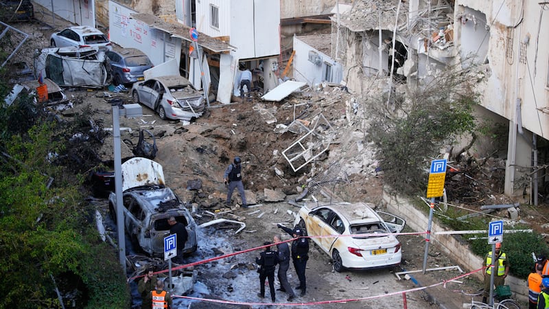 Equipos de rescatistas y seguridad trabajan en el lugar de un misil iraní en Tel Aviv, Israel,...