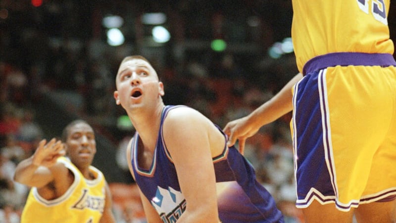 Greg Ostertag, of the Utah Jazz, center, looks for a clear shot as Sean Rooks of the Los...