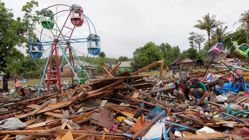 People collect usable items in debris, following Saturday's tsunami in Sumur, Indonesia,...
