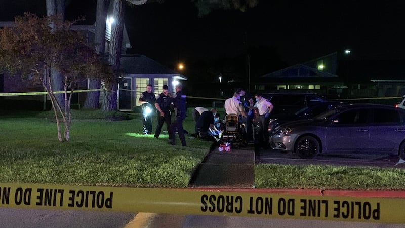 Emergency officials tend to injured victim on sidewalk.
