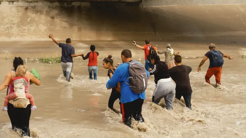 Un grupo de migrantes de Venezuela cruza el Río Grande hacia una instalación de procesamiento...