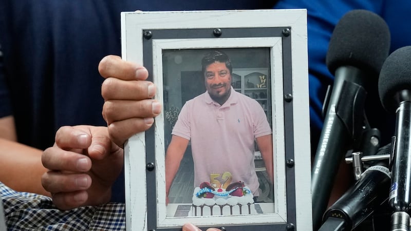 Ronaldo Salgado y Lorenzo Jr., hijos de Lorenzo Salgado Araujo, sostienen una fotografía de su...
