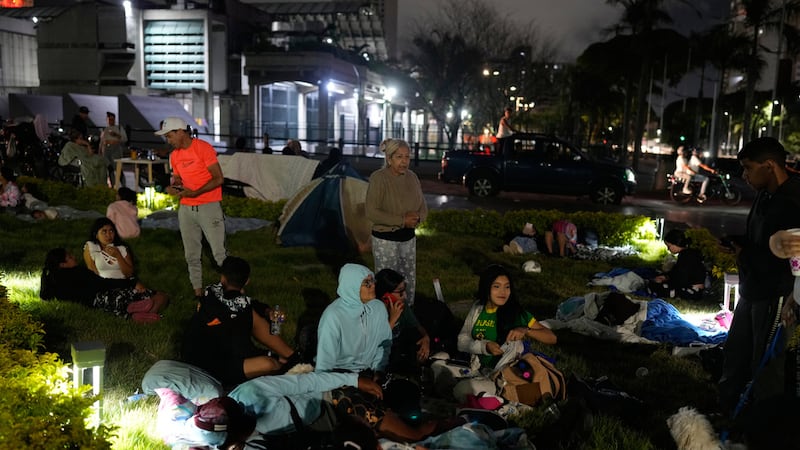 La gente se prepara para pasar la noche al aire libre después de que terremotos sacudieran...