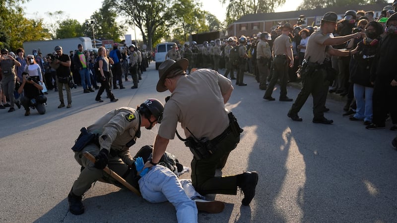 Agentes policiales detienen a un manifestante cerca de una instalación del Servicio de...