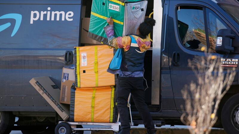 Un repartidor de Amazon Prime levanta paquetes para entregar, el 28 de noviembre de 2023, en...