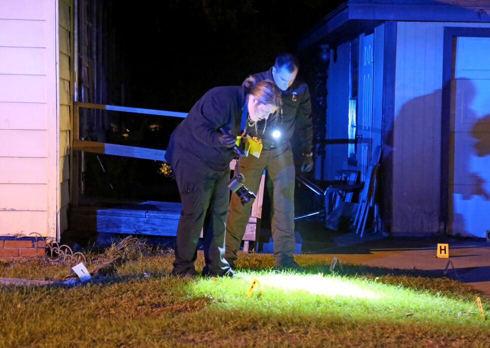 Lufkin Police Department personnel place evidence markers on the ground before taking...