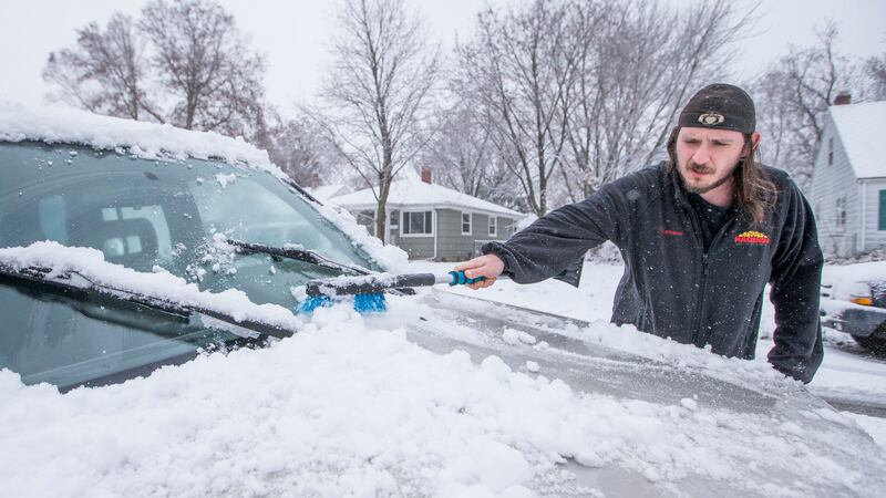 Patrick Kaczmarek, of South Bend, Ind., clears snow off his car on Monday, Nov. 26, 2018,...