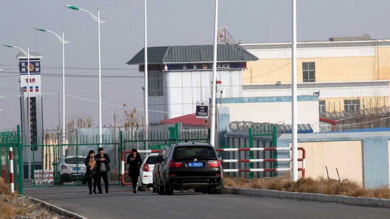 In this Dec. 3, 2018 file photo, people walk by a police station by the front gate of the...