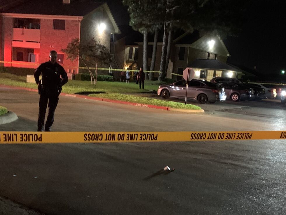 Police place markers at the site of at least two shell casings following a reported shooting.
