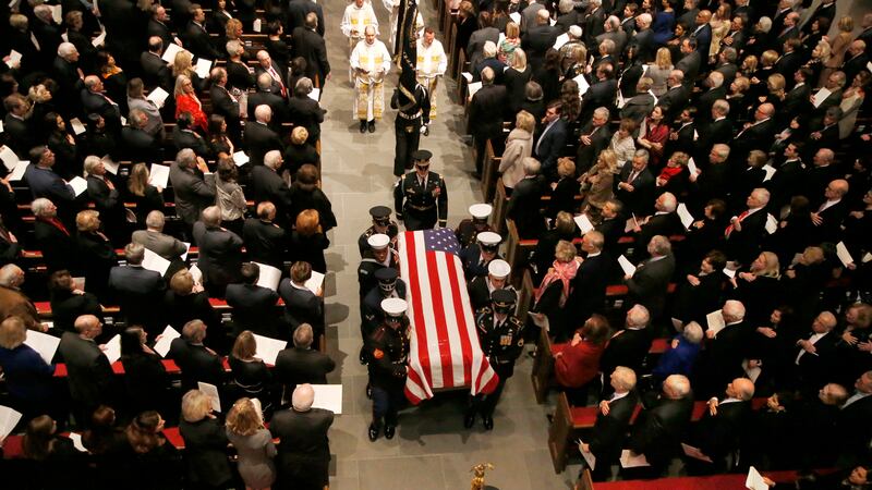 The flag-draped casket of former President George H.W. Bush is carried by a joint services...