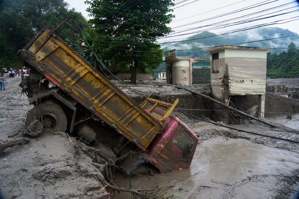 Un vehículo, tras las inundaciones repentinas registradas en Devighat, en el distrito de...