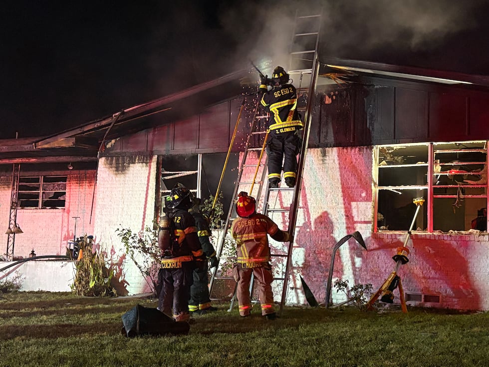 Firefighters with Smith County ESD 2 working to contain hot spots in the attic of a house fire...