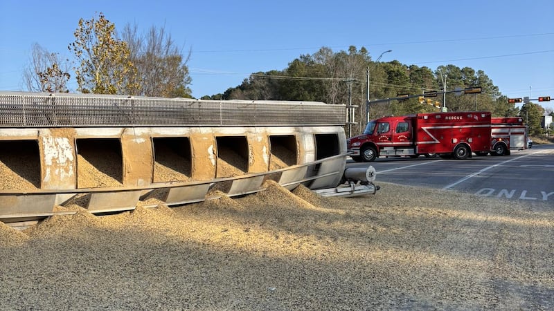 Camión de 18 ruedas volcado y carga derramada en Mineola