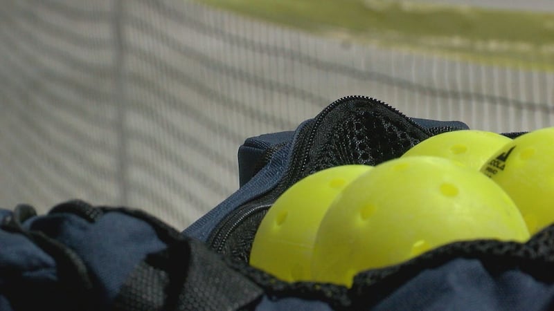 A bag of pickleball balls set up next to a temporary net inside of Tyler Indoor Pickleball....