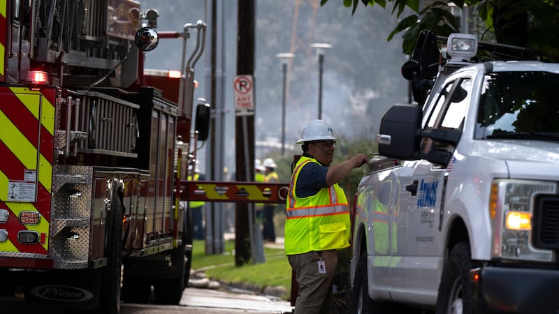 Un empleado de Atmos Energy trabaja en el lugar de un incendio en un complejo de apartamentos...